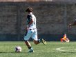 Players engaged in intense soccer action on a sunny outdoor field. Energetic and dynamic sports moment.