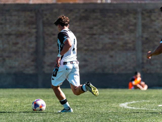 Players engaged in intense soccer action on a sunny outdoor field. Energetic and dynamic sports moment.